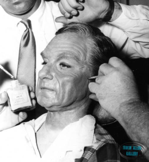 Make-up artists applying adhesive to Dr. Smith mask
